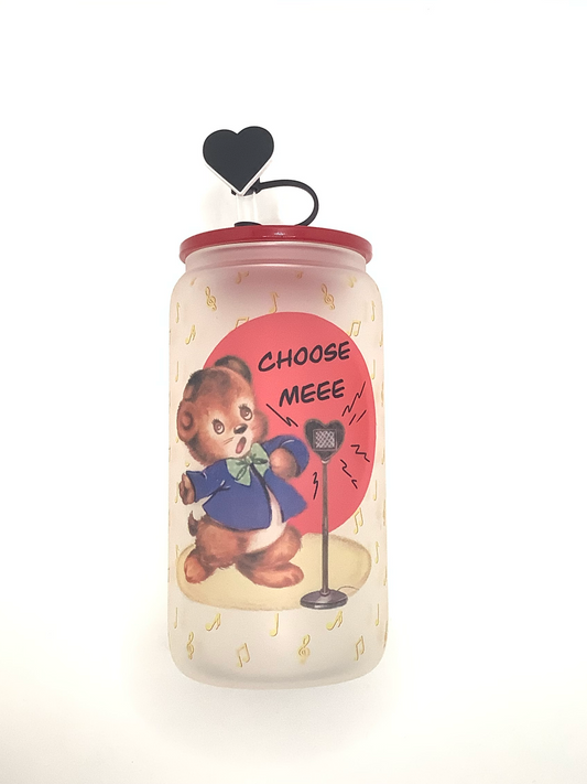 16 oz frosted glass can with sublimated image of a bear in a blue jacket singing "Choose Me" into a heart shaped microphone. Yellow musical notes are the background. Red acrylic lid  with balck heart straw cover 