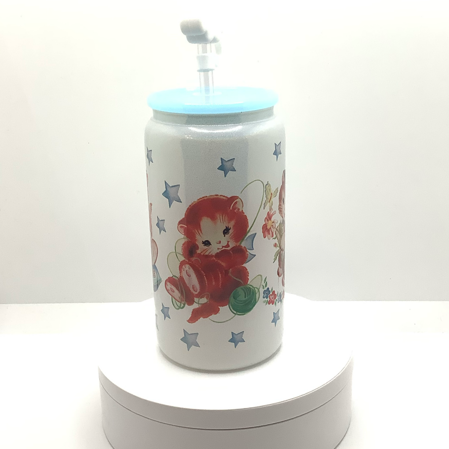 Adorable vintage kittens are sublmated on a 16z white shimmery glass can.   Light blue acrylic lid with white smiling cloud straw cover. 