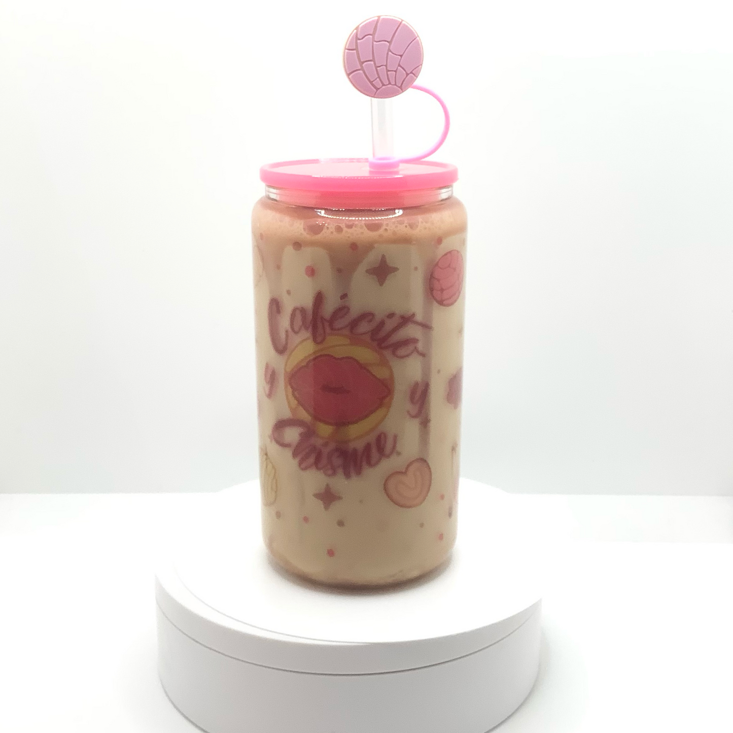 16 oz sublimated snow globe glass can with graphics of popular Mexican cookies found in your local panaderias.  Large Lip Concha in the center of phrase Cafecito y Chisme.  Inside snow globe wall is a caramel resin drip and filled with light mocha colored liquid. Bright pink acrylic lid and Mexican cookie straw cover. 
