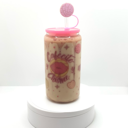 16 oz sublimated snow globe glass can with graphics of popular Mexican cookies found in your local panaderias.  Large Lip Concha in the center of phrase Cafecito y Chisme.  Inside snow globe wall is a caramel resin drip and filled with light mocha colored liquid. Bright pink acrylic lid and Mexican cookie straw cover. 